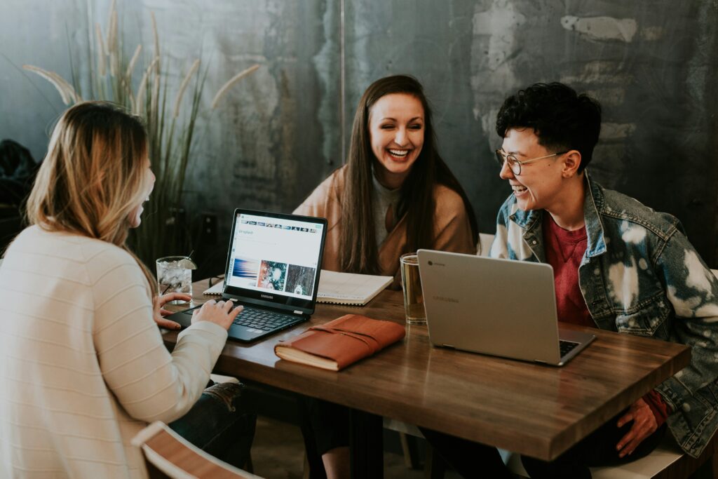 Mensen in gesprek terwijl ze werken achter een laptop